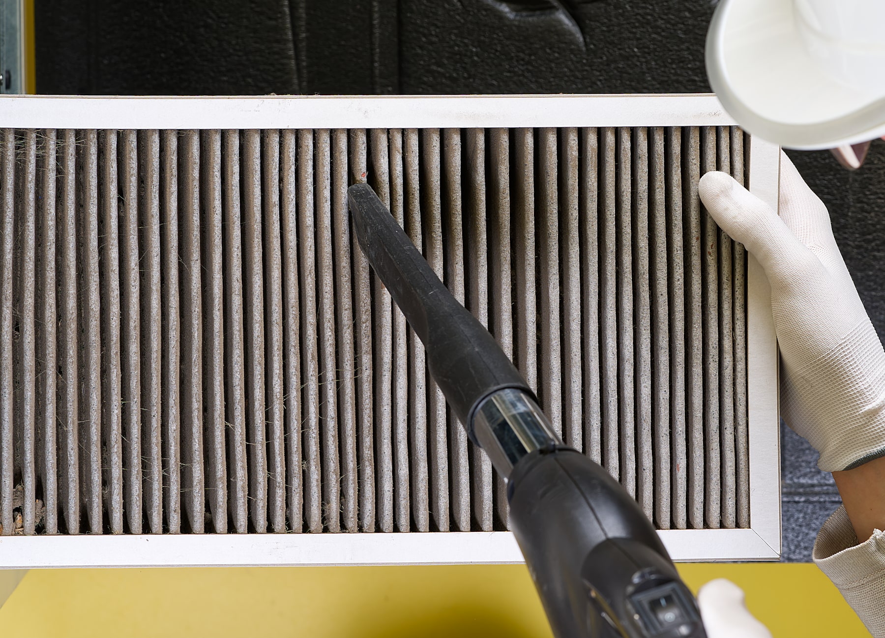 A technician showing how to clean an air conditioner filter.