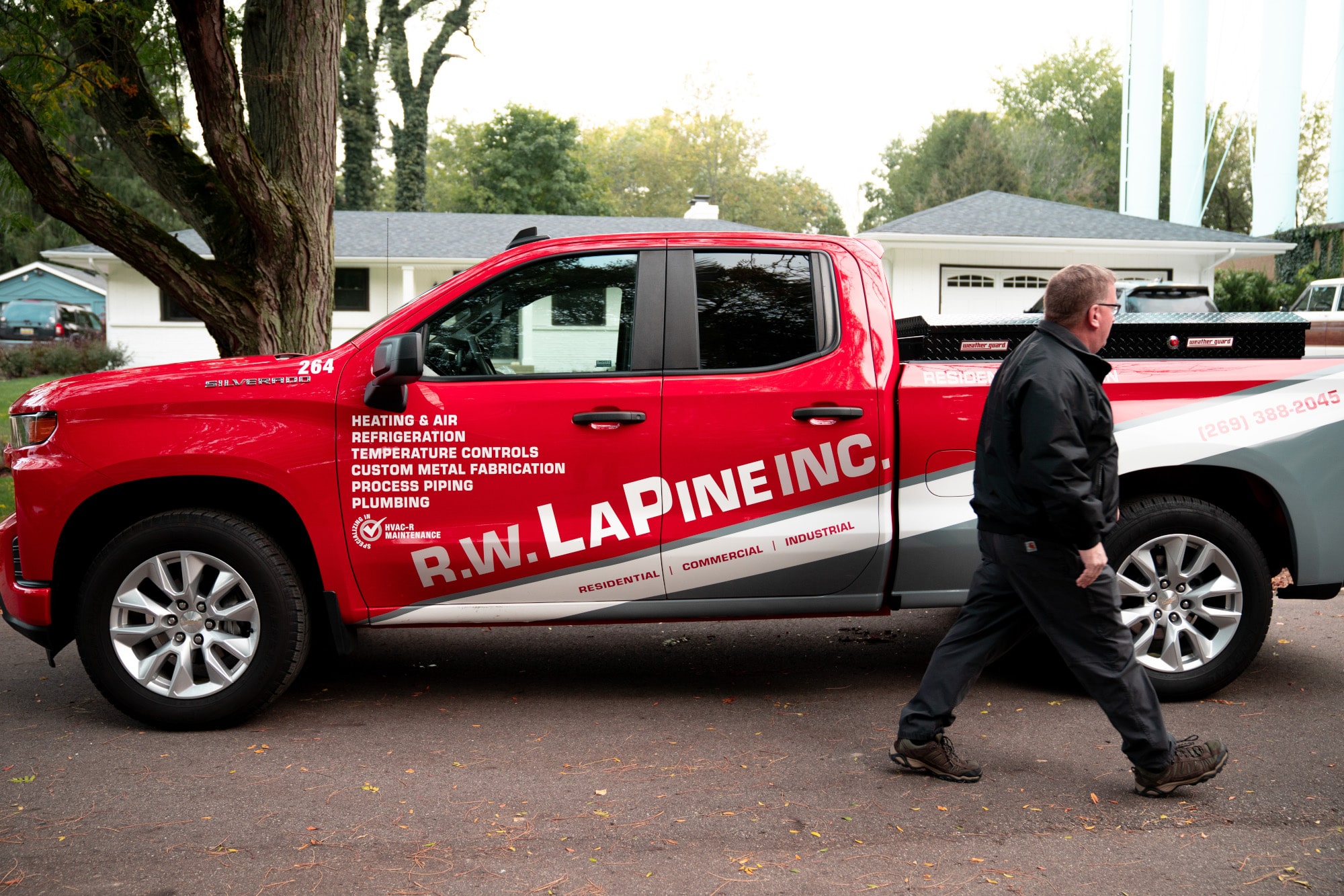 An AC technician leaves his truck to go into a home for an AC tune-up.