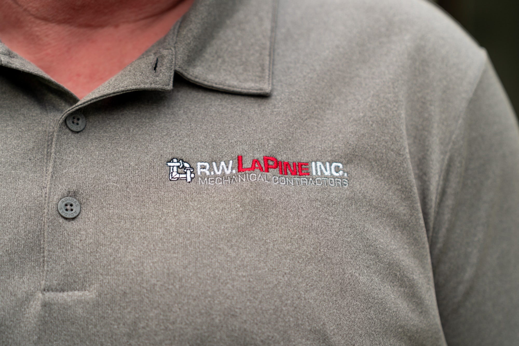 Closeup of an AC technician wearing an R.W. LaPine shirt.