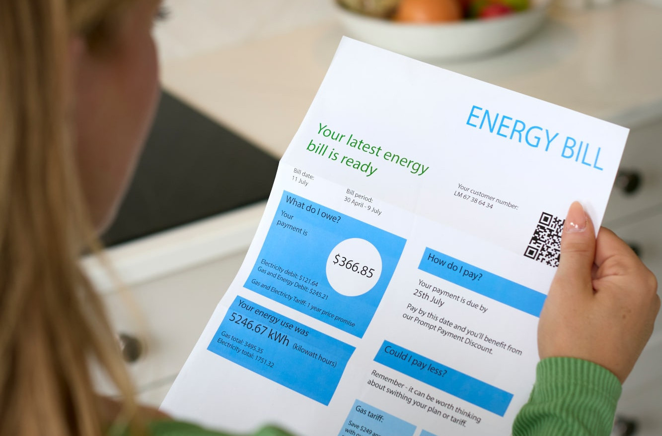 A woman examines her utility bill and considers HVAC energy savings.