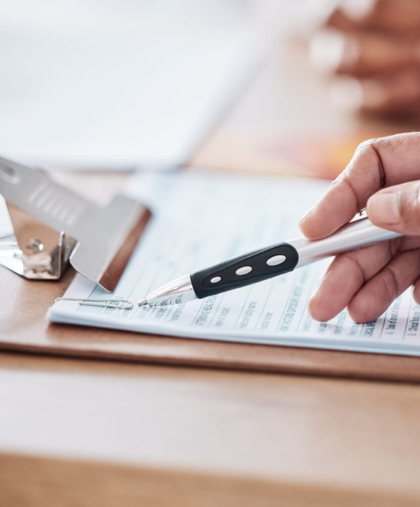 A hand writing up a commercial HVAC maintenance checklist.